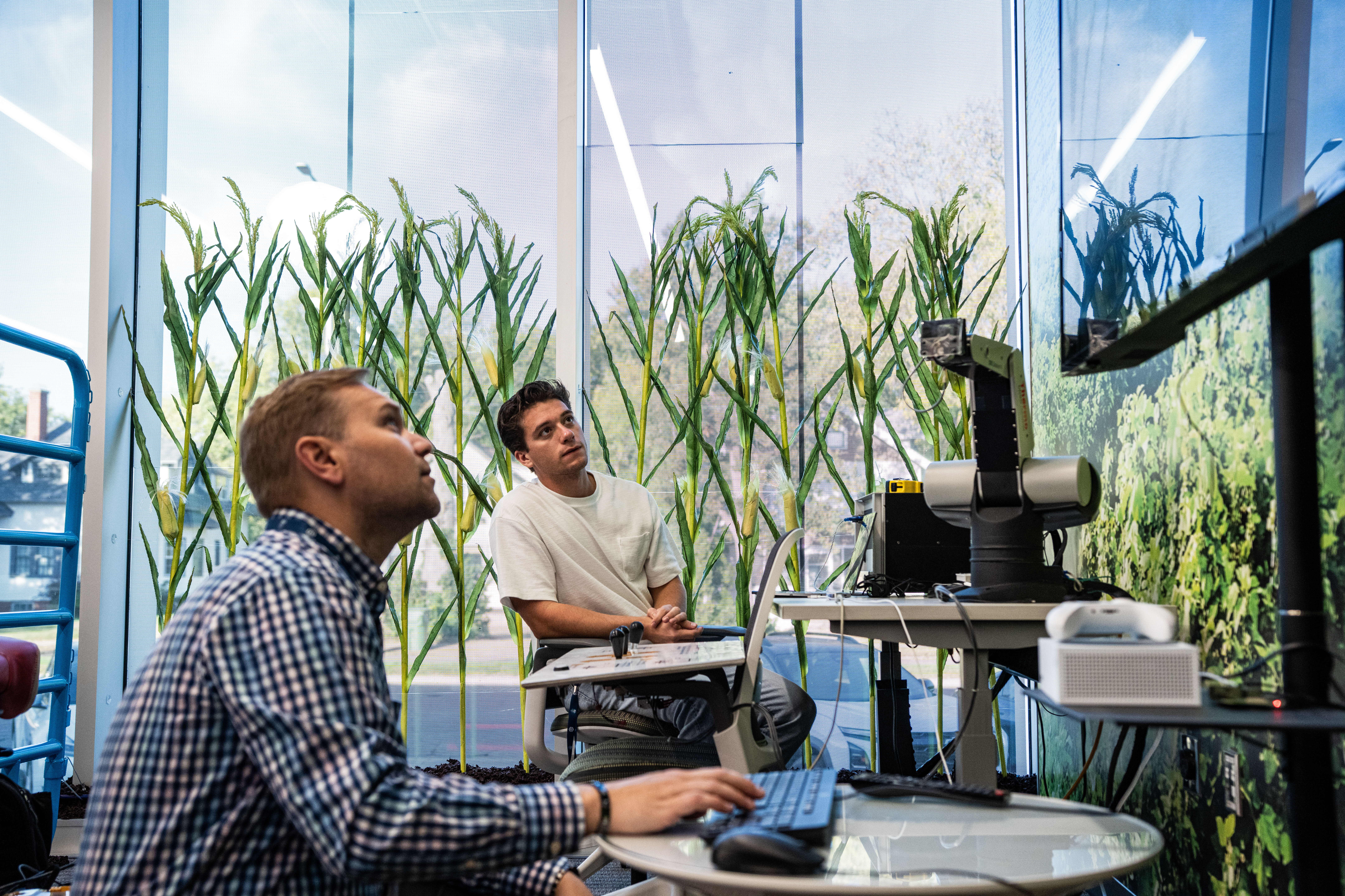 Two males interacting with technical equipment in cyber ag are of Madison Cyber Labs