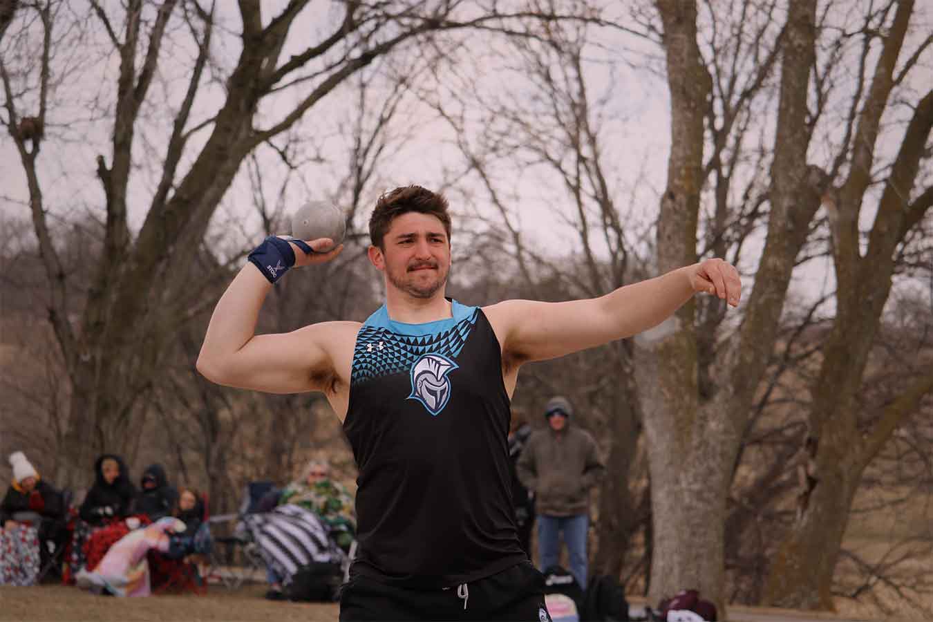 Conner Tordsen prepares to throw at an outdoor track meet.
