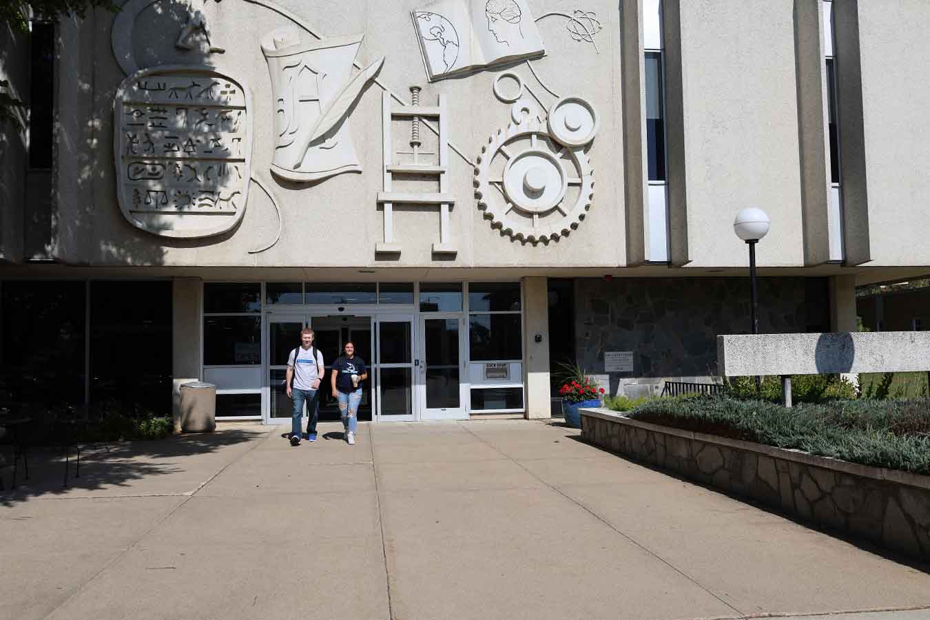 Two students walk out of the Karl Mundt Library.