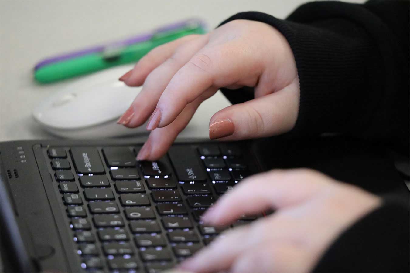 Hands typing on a keyboard.