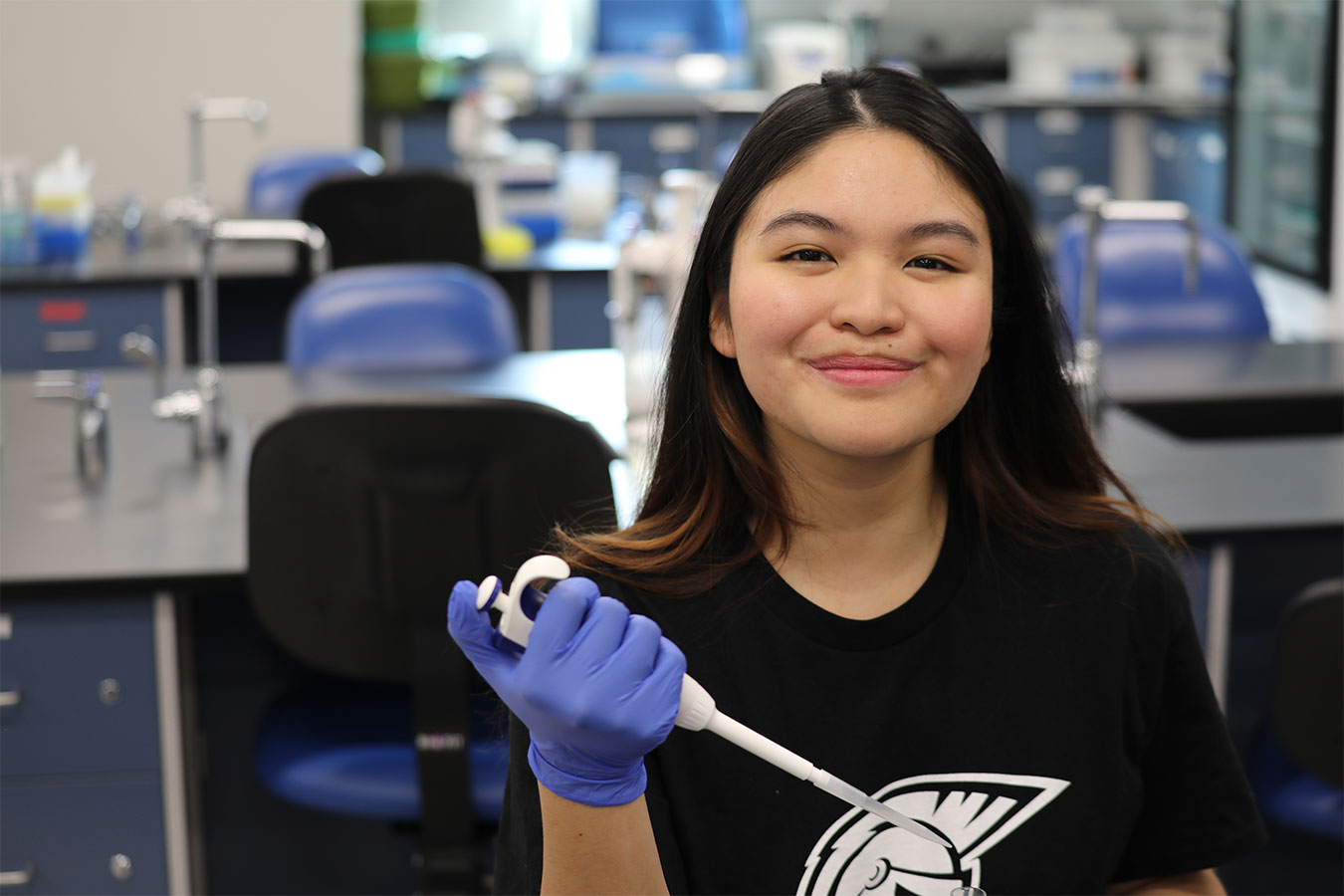 Denyce Bravo holding a pipette in the biology lab at DSU.