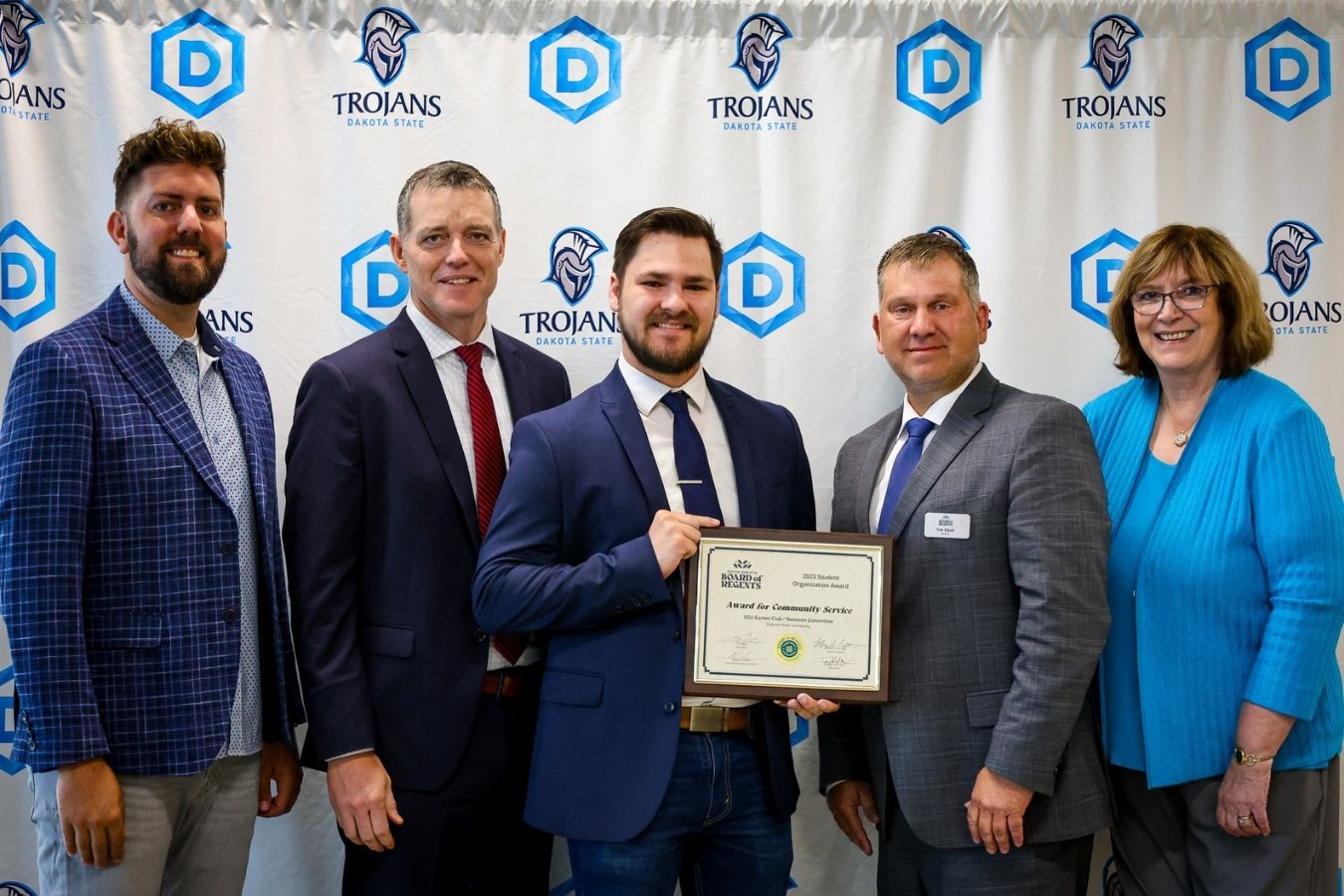 Accepting the Community Service award are Chad Compton and advisor Mark Spanier, along with SD BOR CEO Nathan Lukkes, President Tim Rave, and DSU President José-Marie Griffiths.
