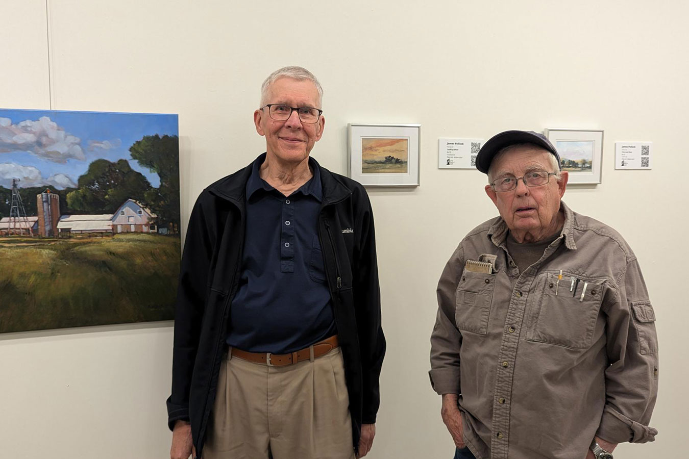 Stephan Randall (left) and James Pollock (right) pose for a photo in front of their artworks in the DSU First Bank and Trust Art Gallery.