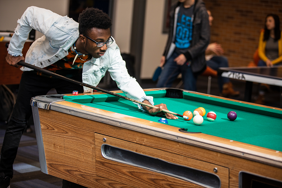 student playing pool in the Trojan Center